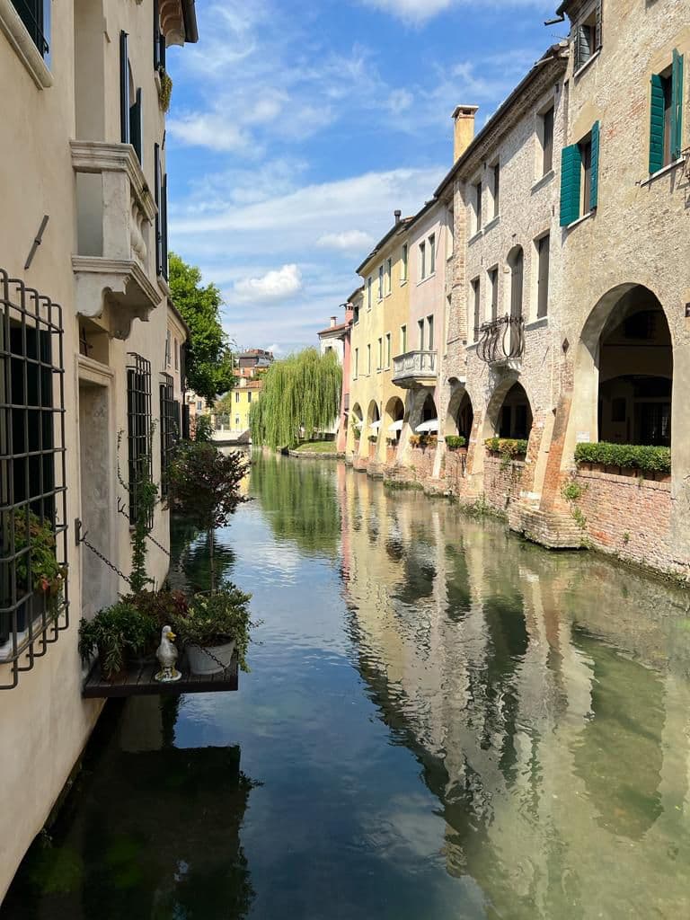 large cream buildings with canal water running through the centre